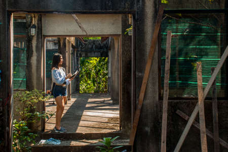 The blue shirt girl is exploring and recording information while walking in the old factory.の写真素材