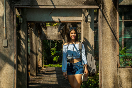 Woman standing poses to take photos in the old warehouse on the way through