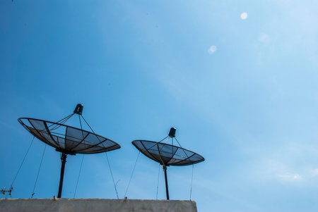 Install satellite dish on the roof on a blue sky backgroundの写真素材