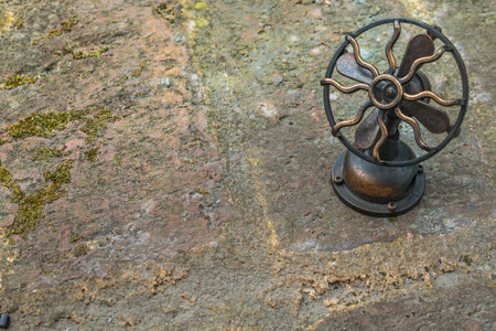Beautiful antique gold brass fan on the stone floor.