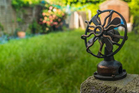 Beautiful antique gold brass fan With a small garden backdrop.の写真素材