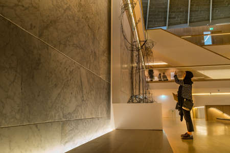 London - Mar 23, 2019 - A Women taking a photo showing at a museum designed in Holland Park, Kensingtonのeditorial素材