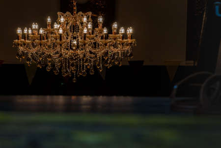 Dark room background interior chandelier light in the dark classic vintage victorian style luxury crystal decor elegant lamp black back. Contemporary interior Concept.の写真素材