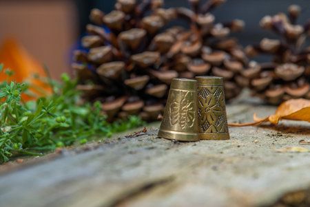 Two brass thimbles on Old wooden floor.