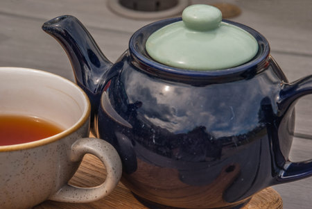 Cup of tea with teapot on a wooden table Cloup-up
