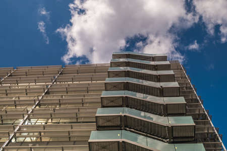 London 6 Jun 62 - Business building with metal emergency ladder / fire escape in modern office buildings with repeating structure and reflected sky and clouds.のeditorial素材