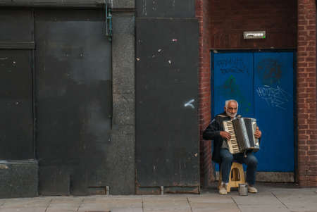 London - May 5, 2019 - Beggar or homeless man play music exchange money, Beggars on the streets of the city. Social problems concept.のeditorial素材