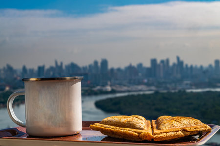 Breakfast - sandwiches and coffee on a wooden tray with natural views.
