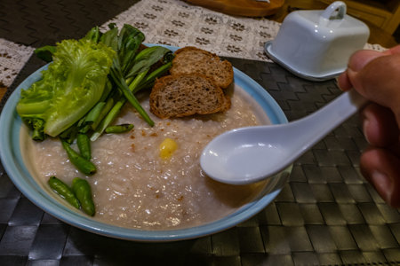 Asian breakfast : Congee, soft boiled rice with ginkgo and vegetables, chilli, Oblique view from the...