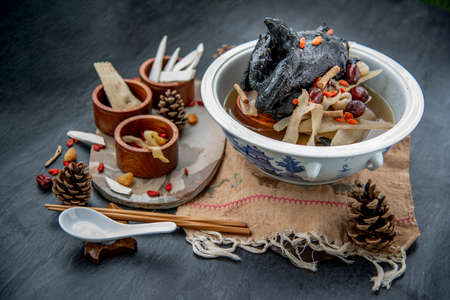 Chinese traditional nourishing health stew, stewed black bone chicken, Chinese black chicken soup, This soup very famous among chinese food and asian food as a healthy soup, food as medicine. Oblique view from the top.の写真素材