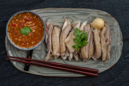 Asian food style marinated steamed chicken (Betong Chickken) and sauce on ceramic plate. Serving chilled as an appetizer. Top view.の写真素材