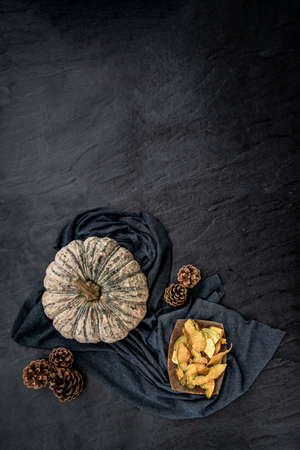 Flat Lay composition with delicious of Homemade crispy pumpkin chips on Black stone texture. Top view.の写真素材