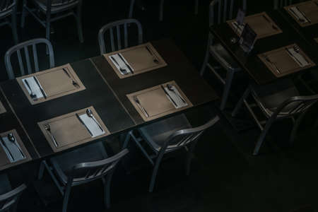 Silver steel chairs and  beautiful wooden tables setting in restaurant. copy space.の写真素材