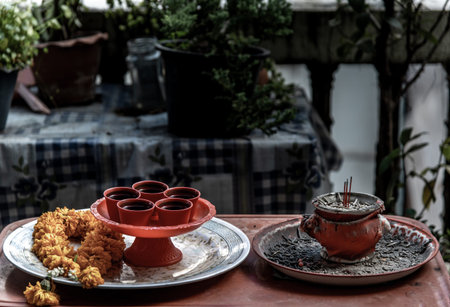 Incense burning in incense pot and marigold flower garlands with tea cup for holy worship for luck,...