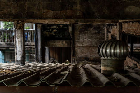 Chimneys on the roof of Deteriorated old building, An abandoned construction, Destroyed building.の写真素材