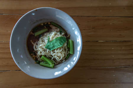 Thai boat noodle soup (Kuaytiaw reua) This delicious Thai noodle soup Local food in Thailand that can be eaten in general is delicious and cheap, Braised pork noodles on the wooden table. Local street food in Thailand, Boat culture noodles style with copy spaceの写真素材