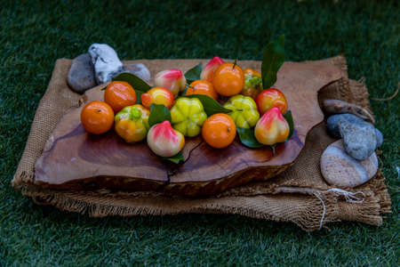 Kanom Look Choup : An old traditional thai dessert made from green been, coconut milk, sugar and jelly, Deletable imitation fruits made from green been, coconut milk, sugar and jelly in fruit shape on wooden, It is a unique dessert of Thailand, Oblique view from the top.の写真素材