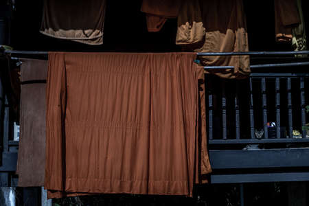 The vibrant orange robes worn by monks hung out to dry in the sun at Wat Chongnonsi.の写真素材