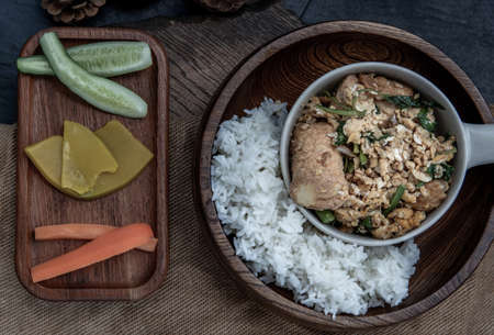 Thai food, Stir fried egg tofu with spring onion with Herbs vegetables served with steamed rice in wooden bowl, view from above.の写真素材