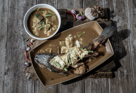 Deep fried whole Snakehad fish topped with Acacia omelets in vegetable sour soup (Orange curry with...