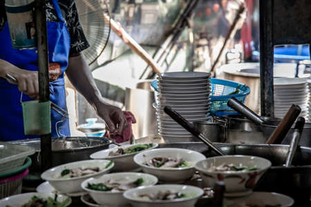 Bangkok, Thailand - 27 Oct 2019 : Chef cooking egg Noodles with roasted pork in local restaurant, Thailand street food. making noodle in Traditional Asian Food. Chinese egg noodle and hot boiled soup, Selective focus.のeditorial素材