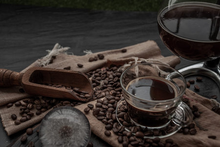 Coffee style, Cup of coffee and coffee beans roating with old wooden scoop and coffee beans around...