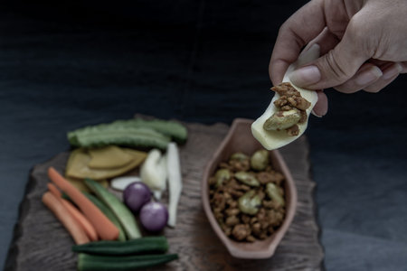 Thai food, The hand is using ginger to scoop Southern Thai dry curry with ground pork Khua Kling,...