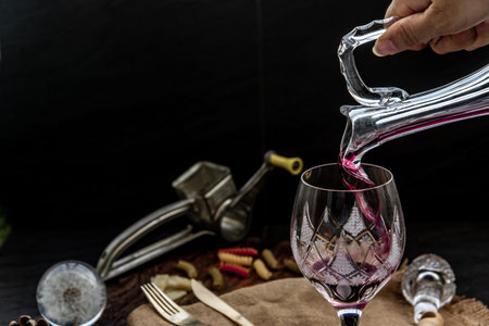 Flat lay composition with Pouring red wine from pitcher into the wineglass : traditional winemaking...