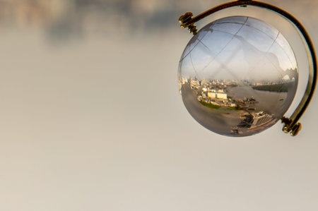 Looking through crystal globe showing city skyline. Refraction photography. Selective focus