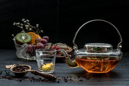Glass of freshly brewed fruit and herbal tea. Darker background.