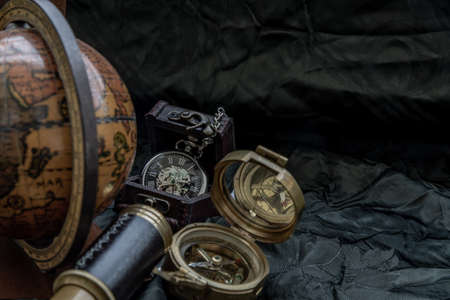 Travel or adventure concept background. Pocket watch, binoculars, antique compass, globe and magnifying glass on dark background. Journey Concept, Copy Space, Vintage Style.の写真素材