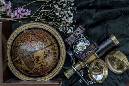 Travel or adventure concept background. Pocket watch, binoculars, antique compass, globe and magnifying glass on dark background. Journey Concept, Copy Space, Vintage Style.の写真素材