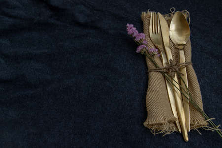 A set of bronze cutlery, spoon, fork and knife black background. Top view, Copy space, Selective focus.の写真素材
