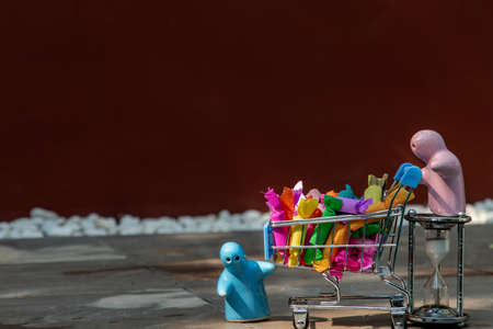 Moments of happiness of a ceramic couple dolls delivery of Colorful jelly toffee in shopping cart. Selective focus.の写真素材