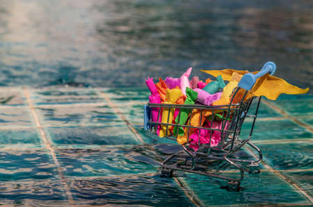 Colorful Jelly toffee in shopping cart on swimming pool background. Giving happiness. Happy holidays.の写真素材