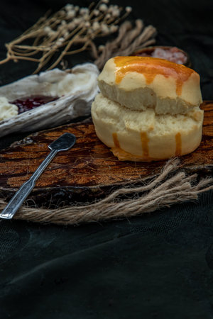 Traditional french sweet dessert : Scones on the wooden tray served with Homemade raspberry jam and...
