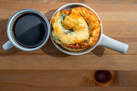 Breakfast with Spinach brioche with Black coffee on wooden table at balcony. Selective focuse.