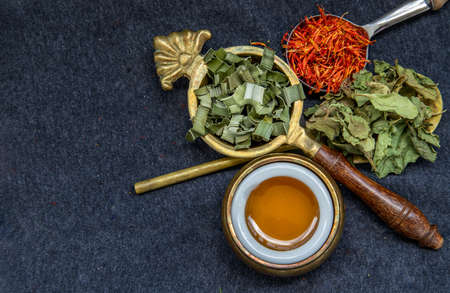 Wonderful Thai herbal tea with Dried pandan herb, indian marsh fleabane and safflower with honey on spoons. Selective focus.の写真素材