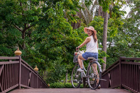 Side view of young woman standing by river and filming vdo on smartphone. Filming or shooting concept.の写真素材