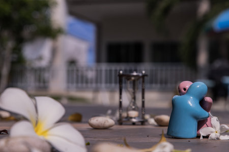 Blue and pink ceramic couple dolls hug with each other on stone background. Concept for anniversary,...