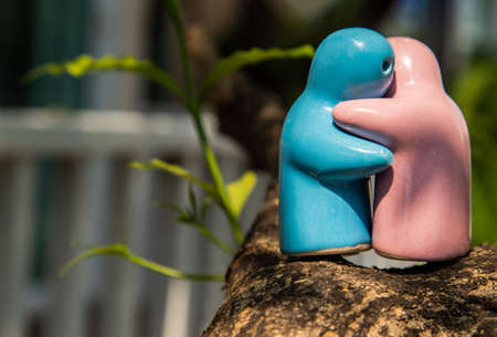 Blue and pink ceramic couple dolls hug with each other on stone background. Concept for anniversary, Wedding and eternal love concept, Romance wedding or Valentineâs day.の写真素材