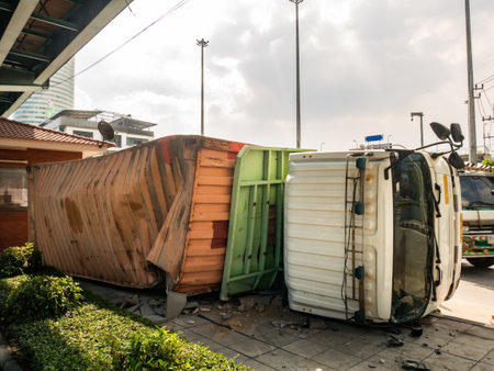 A view of under the truck carrying a container overturned on a road under a bridge over an intersection.のeditorial素材