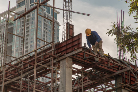 Construction Worker Welding soldering metal girders and Sparks in a Structure high above at the...