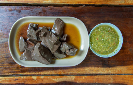 Boiled duck wing stewing in soy sauce Chinese Style on white dish. No focus, specifically.