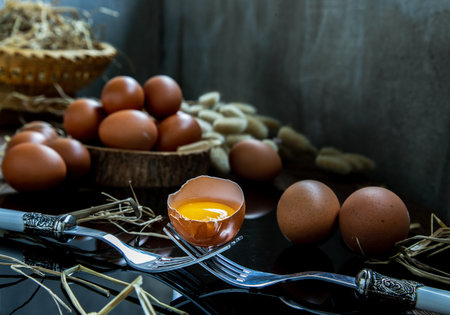 Fresh chicken egg (Hen egg) balanced on a composition of two intertwined forks with fresh chicken...