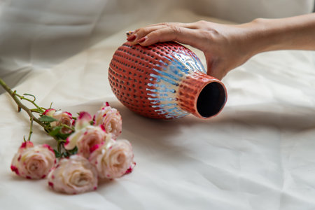 Pink flower in Black and White handmade ceramic vase and on Blush textured table cloth. Home decor,...