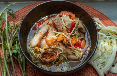 Close-up of Thai papaya spicy salad (som tum) mix grilled pork neck on ceramic dishes. delicious...