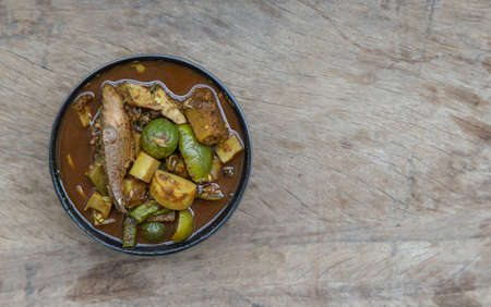 The viscera of mackerel fish paunch hot spicy curry or fish organs sour soup with bamboo shoots and vegetables  in Ceramic bowl. Thai language is Kang Tai Pla, Southern Thai food. Copy space, Selective focus.の写真素材