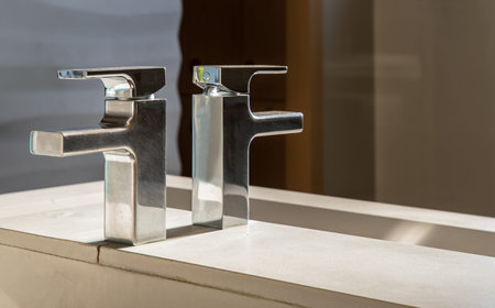 Modern bathroom washbasin with chrome faucet and white tiling. Modern design of bathroom. Space for...