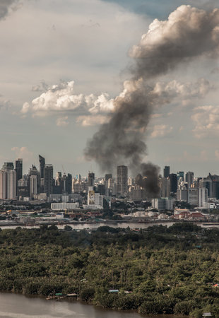 Bangkok, Thailand - 04 Jul, 2021 : Plume of smoke clouds from burnt building on fire at some area in...